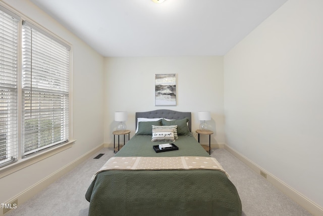 carpeted bedroom featuring visible vents and baseboards