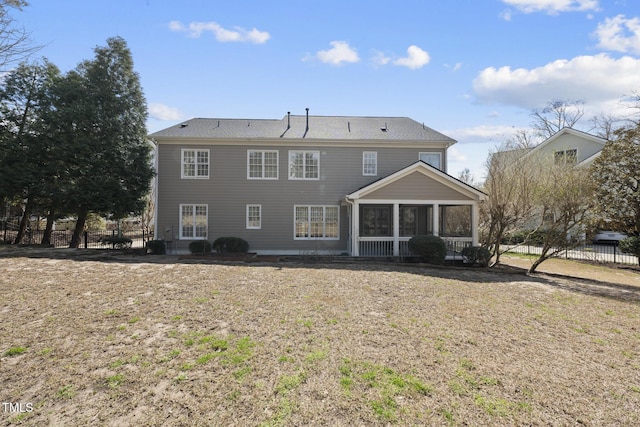 back of house with a yard, fence, and a sunroom