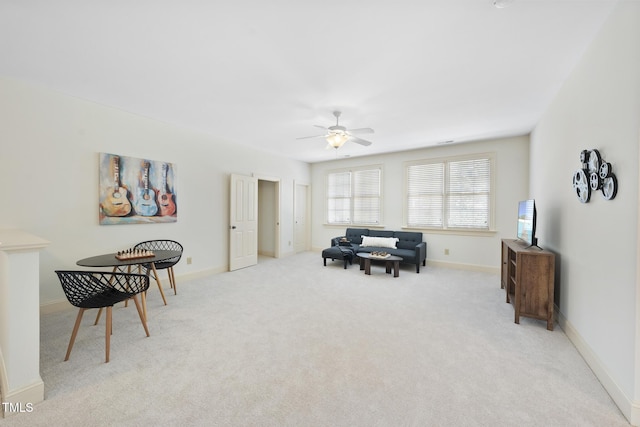 sitting room featuring light colored carpet, baseboards, and ceiling fan