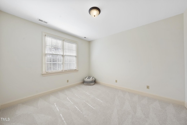 carpeted empty room featuring visible vents and baseboards