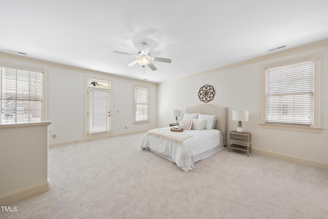 carpeted bedroom featuring visible vents, multiple windows, baseboards, and a ceiling fan