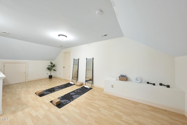 bonus room featuring lofted ceiling, wood finished floors, and visible vents