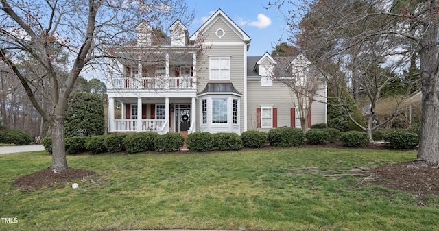 view of front of home featuring a porch, a front lawn, and a balcony