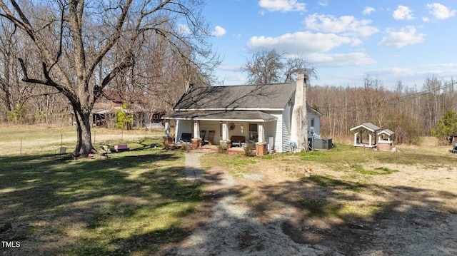2710 Morton Pulliam Rd, Roxboro, NC 27574 - view of side of home featuring covered porch, a lawn, a chimney, an outdoor structure, and a shingled roof