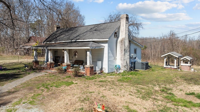 2710 Morton Pulliam Rd, Roxboro, NC 27574 - view of home's exterior featuring covered porch, a chimney, cooling unit, a shingled roof, and a lawn