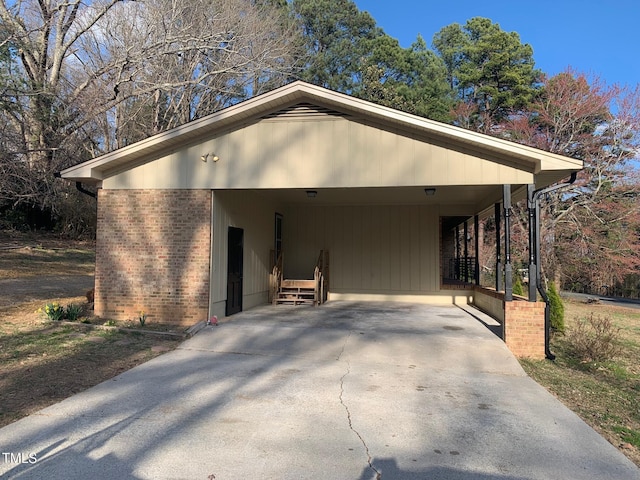 view of front of home featuring concrete driveway, a carport, and brick siding