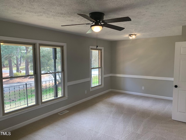 unfurnished room featuring carpet flooring, visible vents, baseboards, and a textured ceiling