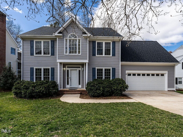 colonial home featuring driveway, a shingled roof, an attached garage, and a front yard