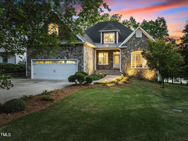 view of front of property featuring a front lawn, concrete driveway, metal roof, a garage, and stone siding