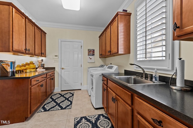 laundry room featuring crown molding, washer and clothes dryer, light tile patterned floors, cabinet space, and a sink