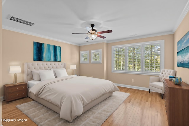 bedroom featuring visible vents, light wood-style flooring, crown molding, and multiple windows