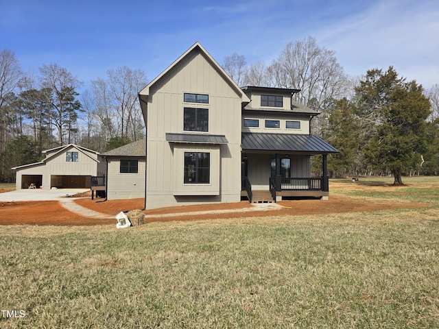 modern farmhouse style home featuring a standing seam roof, roof with shingles, covered porch, a front yard, and metal roof