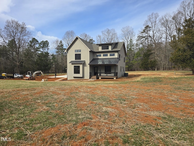 exterior space featuring a standing seam roof, central AC unit, board and batten siding, and metal roof