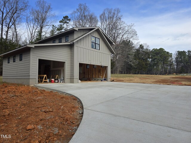 view of home's exterior with a garage, board and batten siding, and concrete driveway