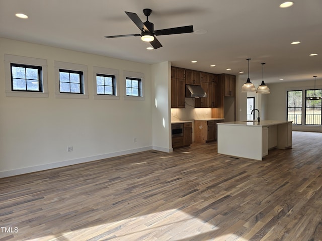 kitchen with dark wood-style floors, recessed lighting, open floor plan, and under cabinet range hood