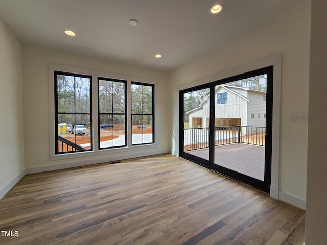 unfurnished room with recessed lighting, baseboards, and wood finished floors