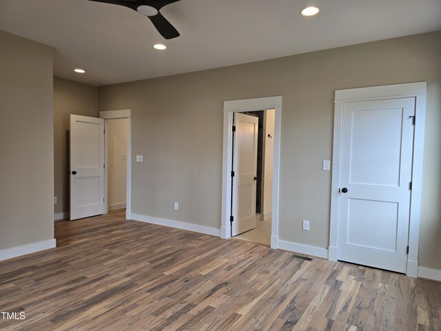 unfurnished bedroom with wood finished floors and baseboards