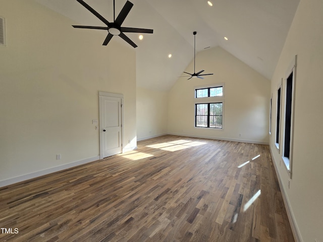 spare room featuring visible vents, high vaulted ceiling, a ceiling fan, wood finished floors, and baseboards