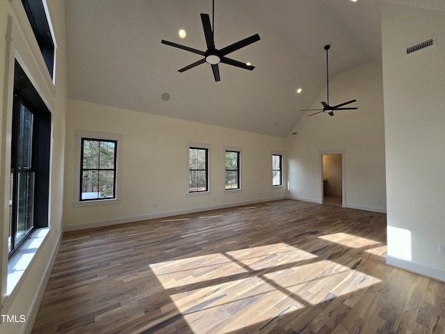 unfurnished living room with wood finished floors, visible vents, a wealth of natural light, and ceiling fan