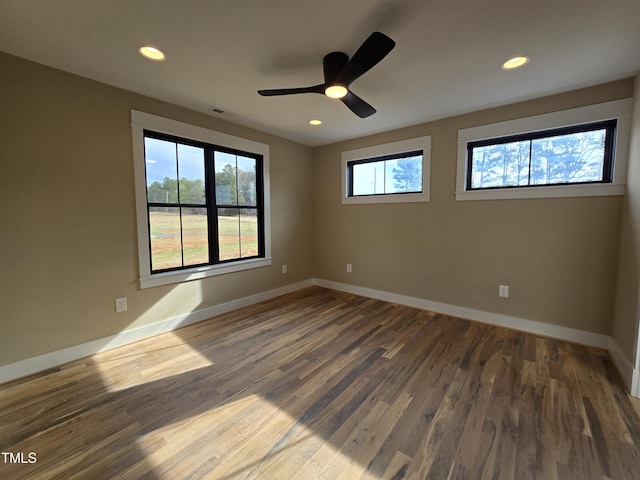 spare room featuring recessed lighting, wood finished floors, and baseboards