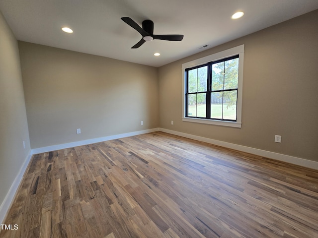 empty room with recessed lighting, visible vents, baseboards, and wood finished floors