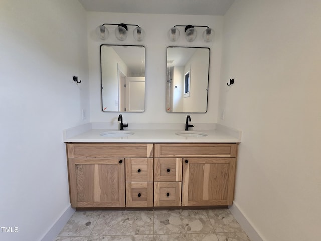 full bath featuring a sink, baseboards, and double vanity