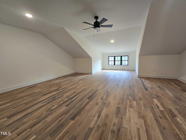 additional living space with ceiling fan, baseboards, dark wood-style floors, and vaulted ceiling