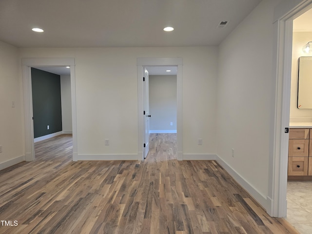 empty room featuring recessed lighting, visible vents, baseboards, and wood finished floors