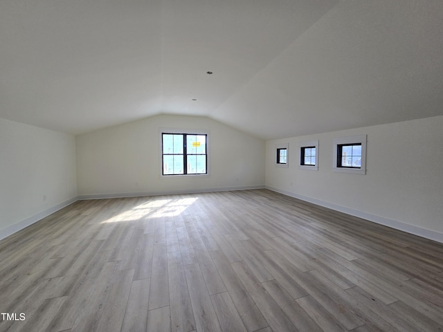 additional living space featuring lofted ceiling, wood finished floors, and baseboards