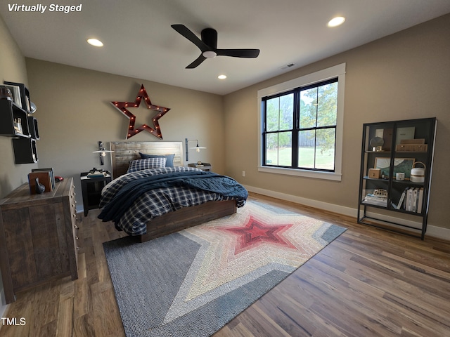 bedroom featuring baseboards, visible vents, wood finished floors, and recessed lighting
