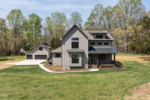 modern inspired farmhouse featuring a front yard, a detached garage, a porch, and board and batten siding