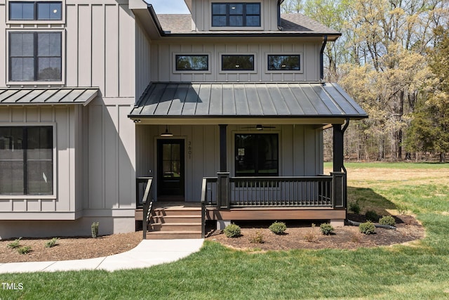 modern inspired farmhouse featuring metal roof, a standing seam roof, a front lawn, board and batten siding, and covered porch