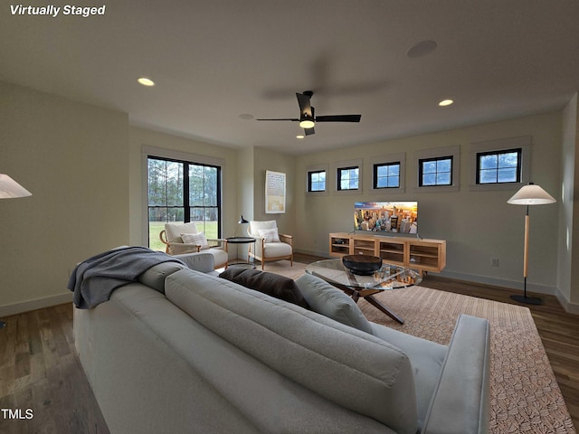 living area with baseboards, wood finished floors, and recessed lighting
