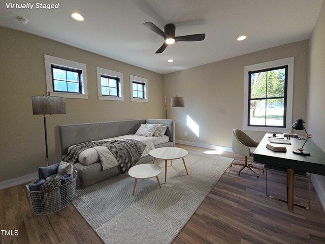 bedroom with multiple windows, wood finished floors, and baseboards