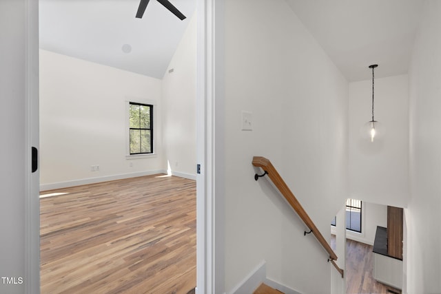 stairs featuring baseboards, high vaulted ceiling, wood finished floors, and ceiling fan