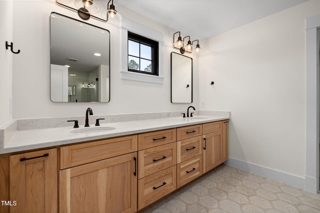 full bath with a shower with door, double vanity, baseboards, and a sink