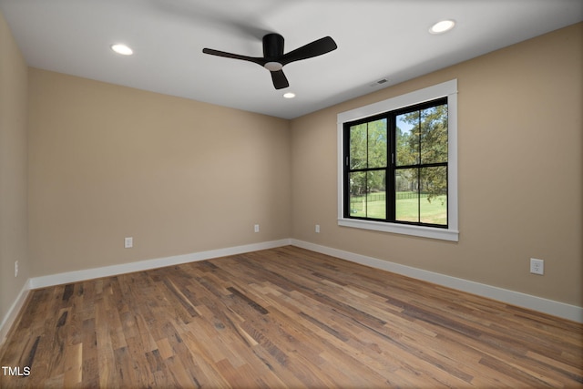 unfurnished room featuring baseboards, wood finished floors, and recessed lighting