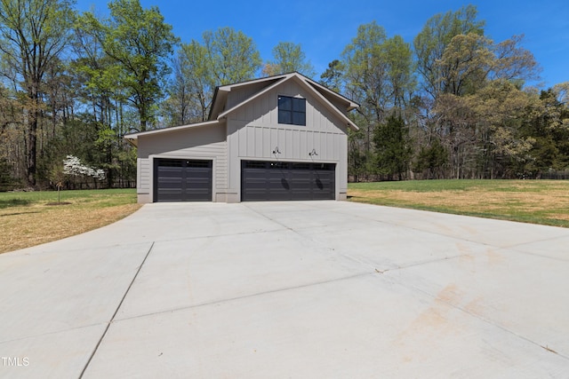 view of property exterior with driveway, an attached garage, board and batten siding, and a yard