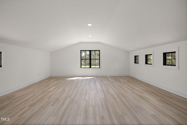 additional living space with light wood-style flooring, baseboards, lofted ceiling, and recessed lighting