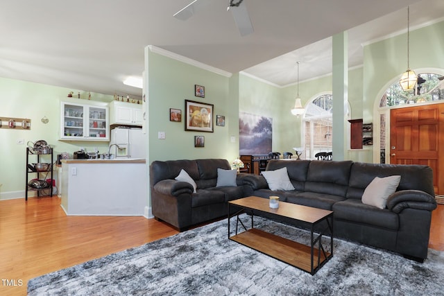 living room with baseboards, wood finished floors, and crown molding