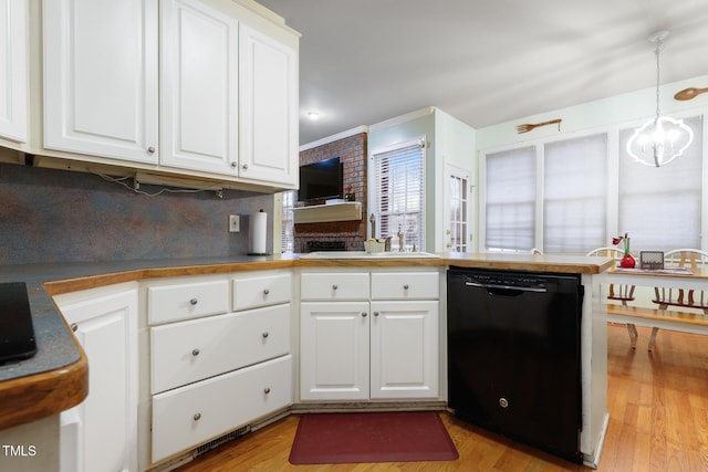 kitchen featuring dishwasher, light wood-style flooring, an inviting chandelier, white cabinetry, and a sink