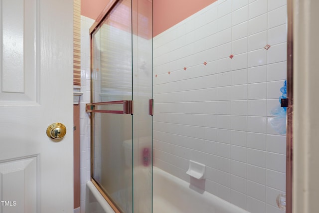 bathroom featuring combined bath / shower with glass door