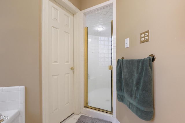 full bathroom with tile patterned floors and a stall shower