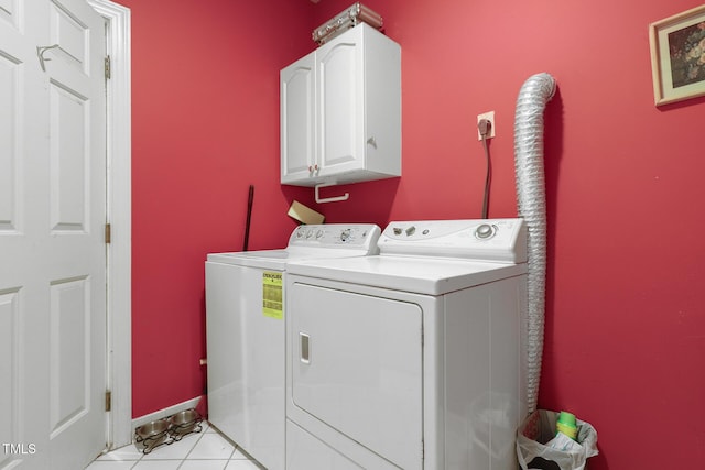 laundry area featuring washing machine and clothes dryer, cabinet space, baseboards, and light tile patterned flooring