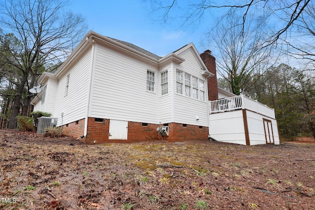 view of home's exterior featuring crawl space, central AC unit, and a chimney