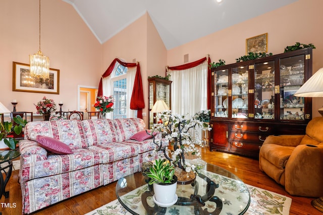 living room featuring vaulted ceiling, a notable chandelier, and wood finished floors