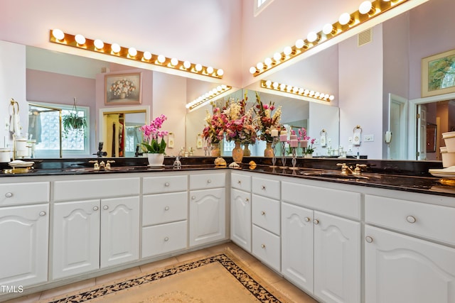 bathroom with tile patterned flooring, double vanity, visible vents, and a sink