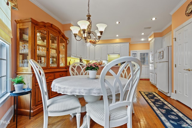 dining room with recessed lighting, light wood-style floors, an inviting chandelier, and ornamental molding