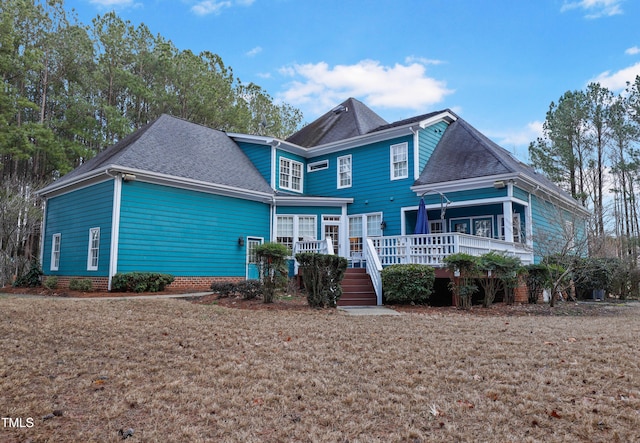 view of front of home with a front yard and a shingled roof