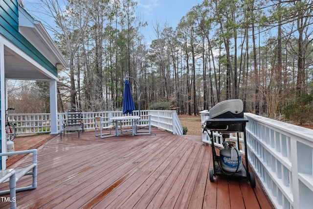 deck with a grill and outdoor dining area